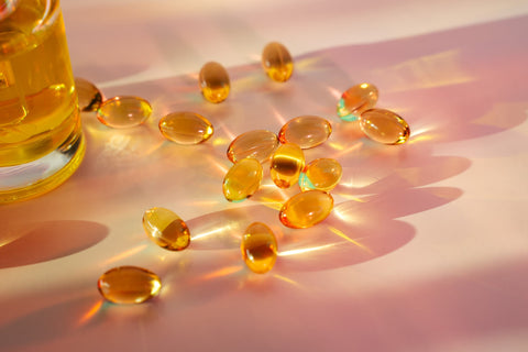 Vitamin D capsules laid out on the table next the jar they are contained in.